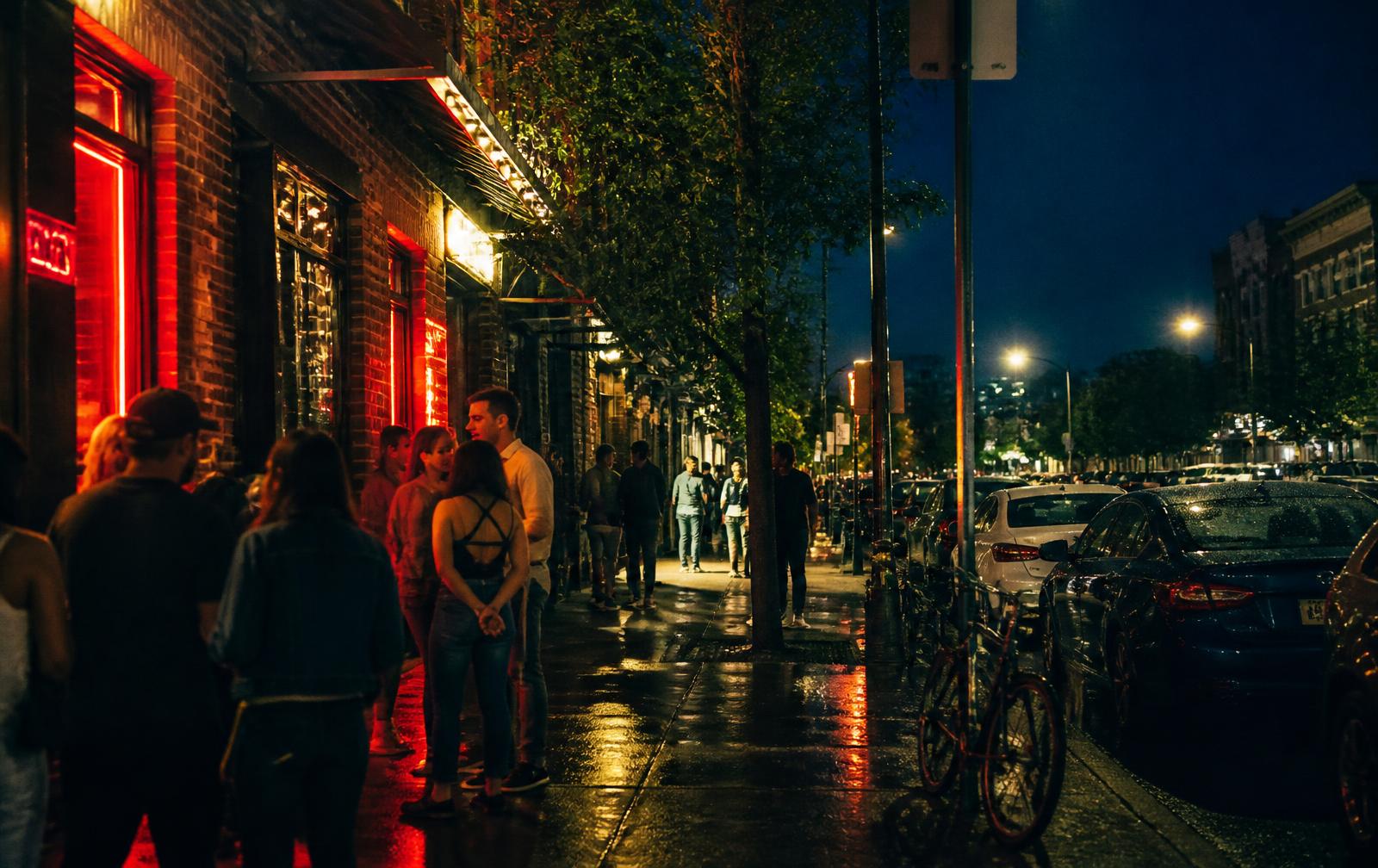 Nightlife block with neon light reflecting on wet pavement in Charlotte